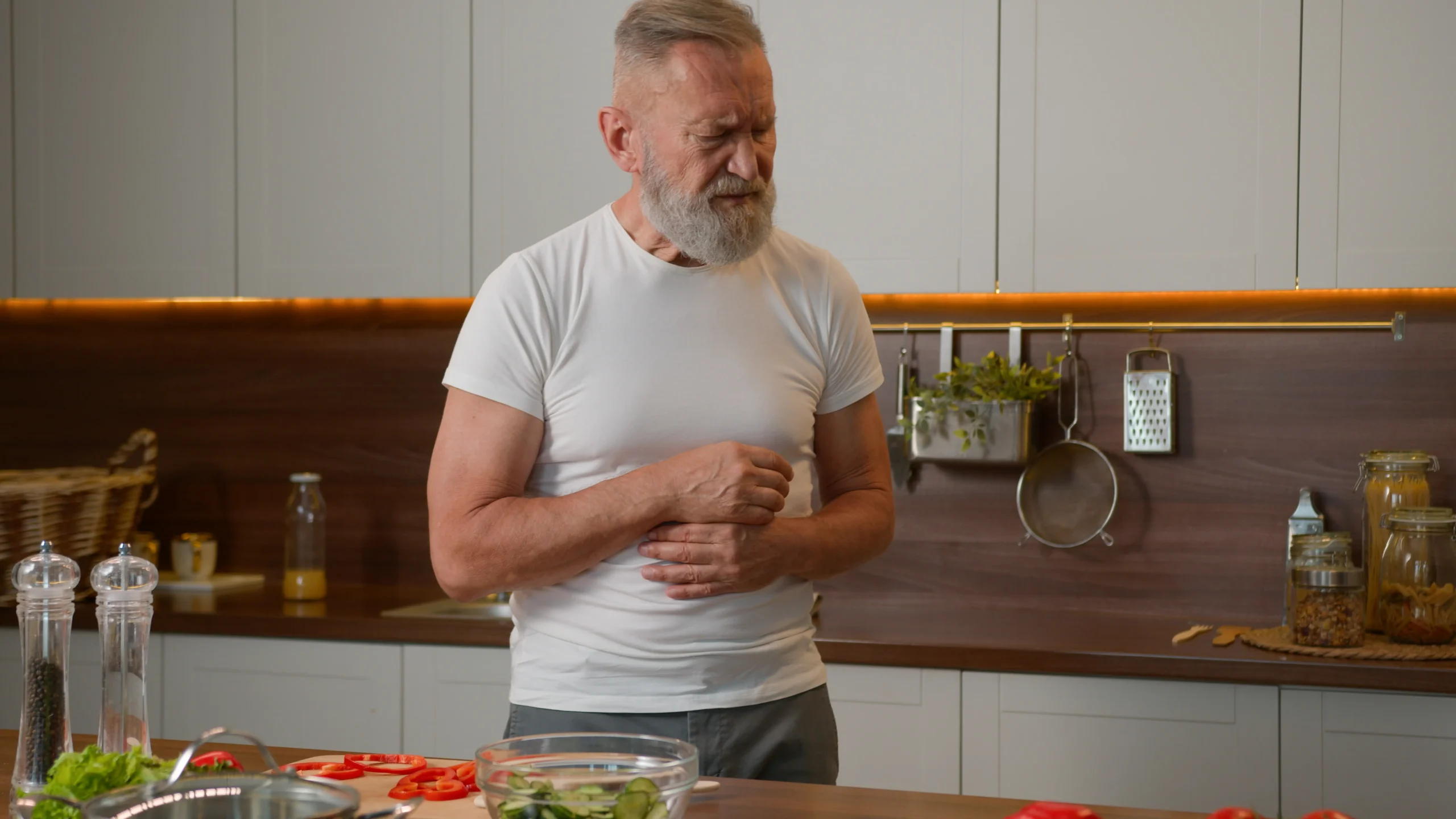 A man holds his stomach, showing a bloated stomach after a healthy meal.