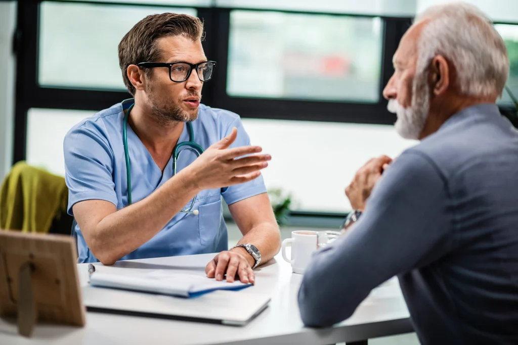 A doctor talks with an older patient, showing how speaking up supports patient safety.